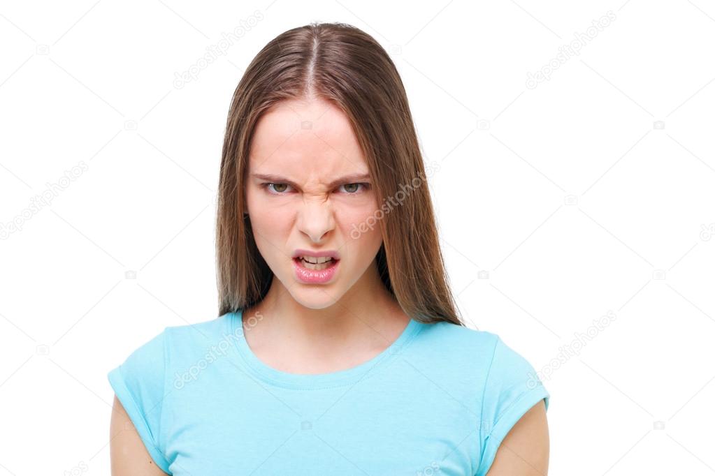 Aggressive face of a young girl isolated on white.