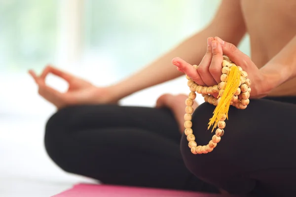Nilüfer çiçeği pozunda meditasyon yapan genç bir kadın..