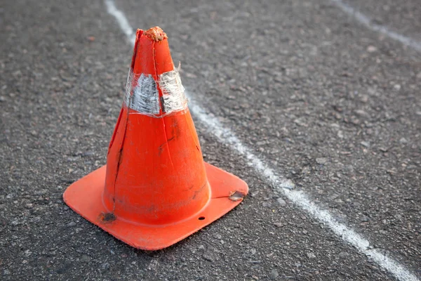 Vecchio cono a strisce arancioni su strada . — Foto Stock