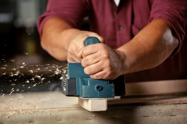 Carpenter working with electric planer. — Stock Photo, Image
