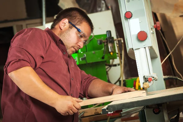 Professioneller Schreiner arbeitet mit Sägemaschine. — Stockfoto