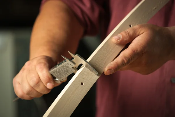 Carpenter measuring chair part with electric callipers. — Stock Photo, Image