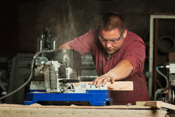 Menuisier professionnel travaillant avec une machine à scier. — Photo