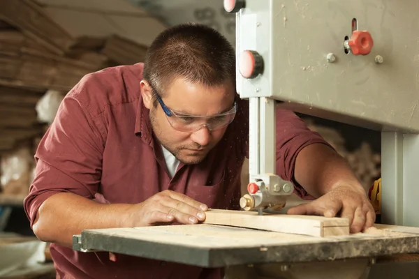 Carpintero profesional que trabaja con la máquina de aserrar. — Foto de Stock
