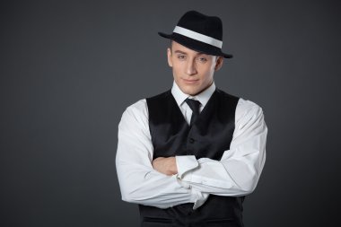 Genç erkek kendine güvenen erkek gangster tarzı süitte poz.