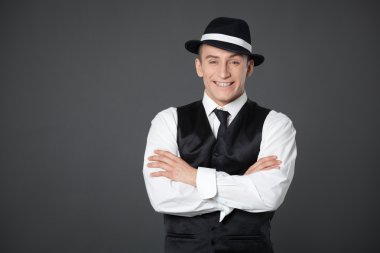 Genç erkek kendine güvenen erkek gangster tarzı süitte poz.