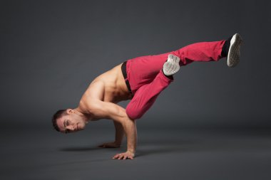 Genç erkek profesyonel dansçı B-boying gri arka plan üzerinde.
