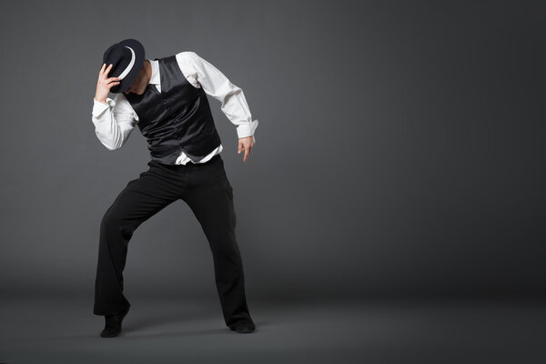 Танцующий в студии молодой профессиональный танцор.