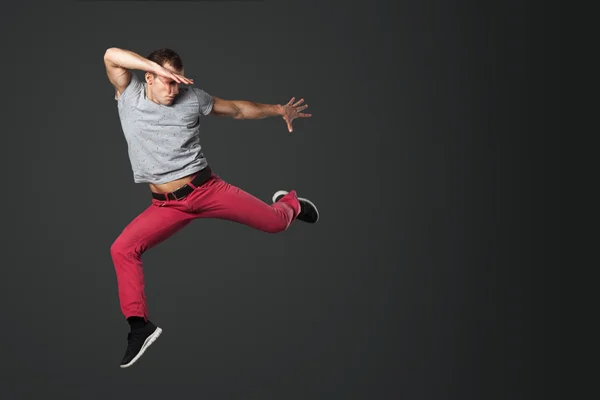 Młody mężczyzna tancerz skoki w studio. — Zdjęcie stockowe