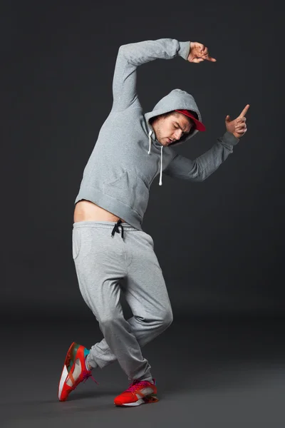 Retrato de cuerpo completo de un joven genial bailando sobre un fondo oscuro . —  Fotos de Stock