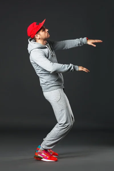 Fullbody portrait of young cool man dancing on dark background. — Stock Photo, Image