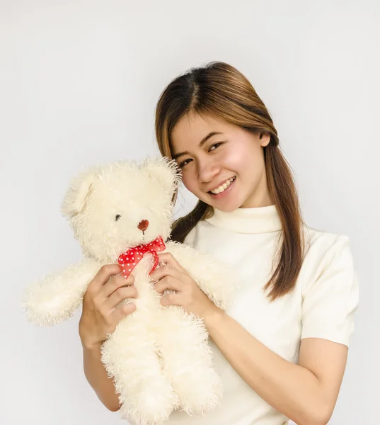 Asian teen holding a  bear doll. — Stock Photo, Image