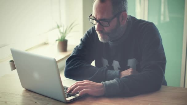 Hombre de negocios creativo trabajando con el ordenador portátil en su de su oficina / agencia — Vídeo de stock