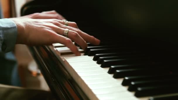 Молодой человек играет на пианино, играет быструю музыку, меняет фокус движения камеры — стоковое видео