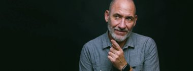 Siyah arka planda modern, olgun bir iş adamının portresi.