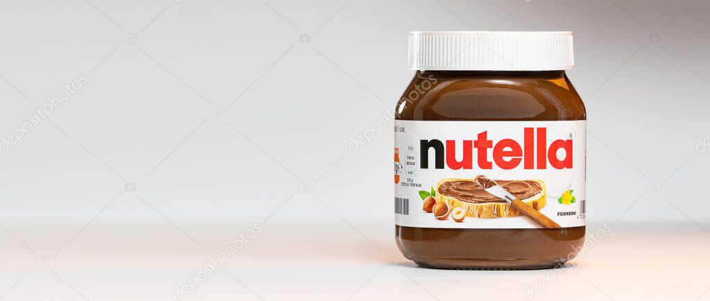 AACHEN, GERMANY - JAN 07, 2021: Pot of Nutella, the popular brand name of a sweetened hazelnut cocoa spread, introduced to the market in 1964 by Italian company Ferrero who celebrates 75 years anniversary in 2021