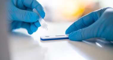 Hızlı antijen test kiti kullanan bir adam. Hızlı antijen testleri, Sars-CoV-2 belirtisi göstermeyen insanlarda Corona COVID-19 'un tespit edilmesine yardımcı olan bir tarama aracıdır..