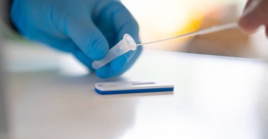 Hızlı antijen test kiti kullanan bir adam. Hızlı antijen testleri, Sars-CoV-2 belirtisi göstermeyen insanlarda Corona COVID-19 'un tespit edilmesine yardımcı olan bir tarama aracıdır..