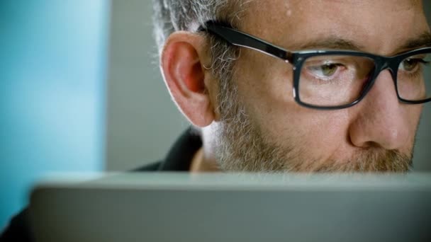 Mann mit Brille arbeitet am Laptop — Stockvideo