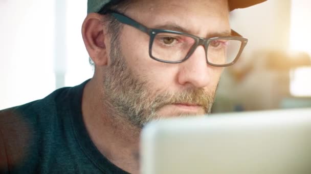 Man met bril werkt op laptopcomputer — Stockvideo