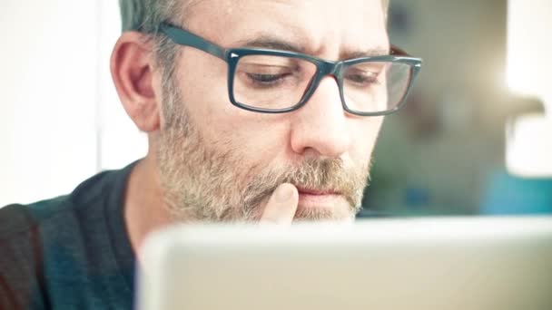 Человек в очках работает на ноутбуке — стоковое видео