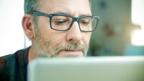 Чоловік в окулярах працює на портативному комп'ютері — стокове відео