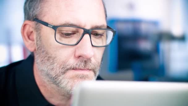 Mannen med glasögon som arbetar på bärbar dator — Stockvideo