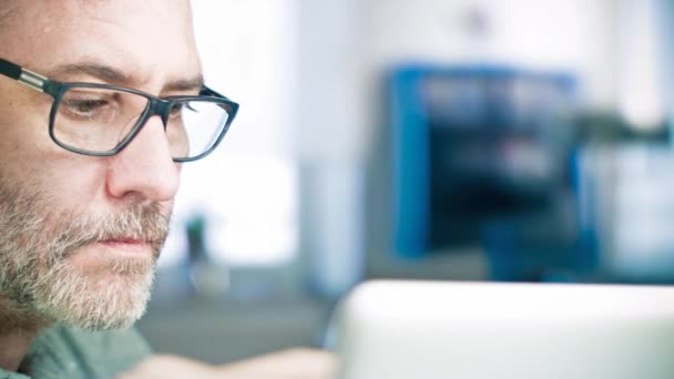 Hombre con gafas de trabajo en el ordenador portátil — Vídeos de Stock