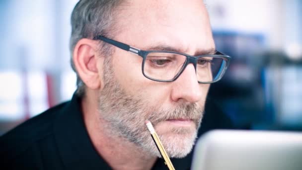 Άνδρας με γυαλιά που εργάζονται στο φορητό υπολογιστή — Αρχείο Βίντεο