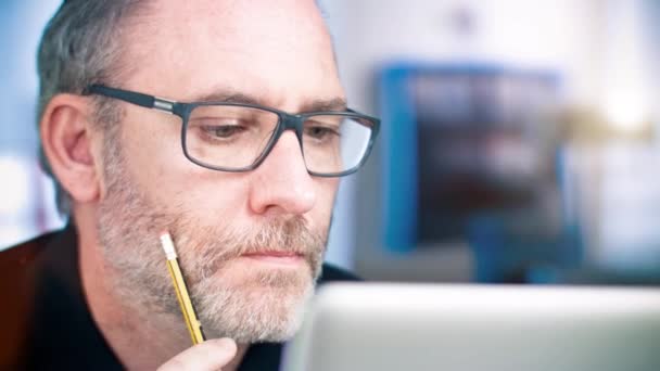 Muž s brýlemi, které pracují na přenosném počítači