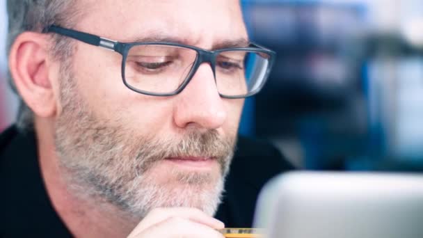 Man met bril werkt op laptopcomputer — Stockvideo