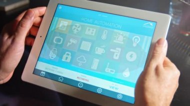 Adam onun tablet Pc kullanan smarthome uygulaması ile evini kontrol etmek için