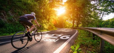 Yeni yıl 2026 ya da düz ve başlangıç konsepti. Bisikletli bir adam ve 2026 numara gün batımında mercek parlamasıyla yola koyuluyor. Zorluk kavramı veya kariyer yolu, iş stratejisi.