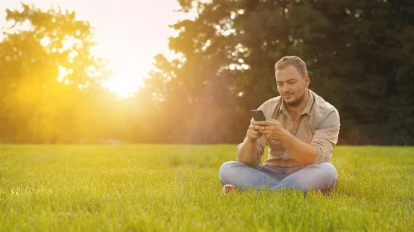Jovem homem usando smartphone ao ar livre — Fotografia de Stock
