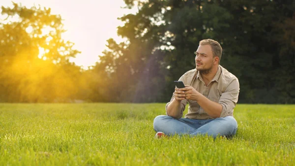 Jonge man gebruikend smartphone in de open lucht — Stockfoto