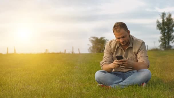 Hombre joven utilizando el teléfono inteligente al aire libre — Vídeos de Stock