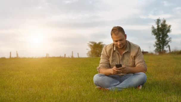 Jonge man gebruikend smartphone in de open lucht — Stockvideo