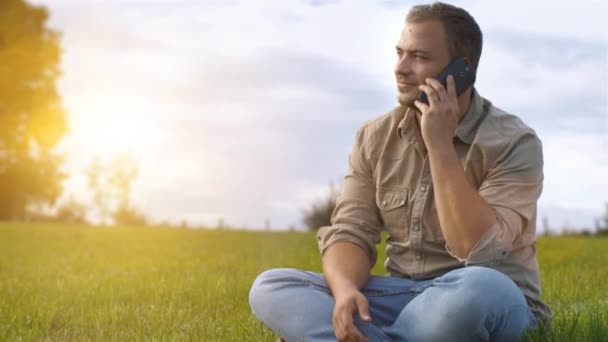 Joven hablando en el teléfono inteligente al aire libre — Vídeo de stock