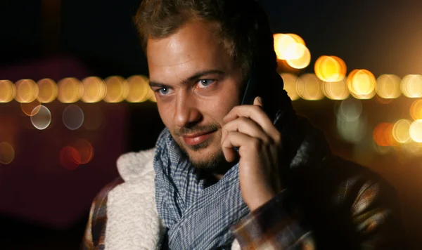 Handsome young man speaking on smartphone — Stock Photo, Image