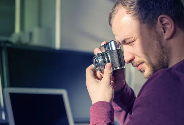 Jeune homme avec caméra prenant une photo — Photo