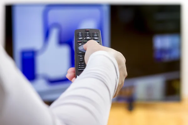 Primer plano en la mano de la mujer sosteniendo el control remoto —  Fotos de Stock