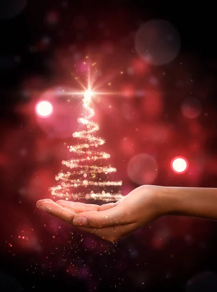 手に赤いクリスマスツリー クリスマスツリー 美しいライト 星と雪の結晶 ストック画像