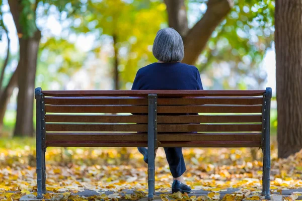 Ηλικιωμένη Γυναίκα Κάθεται Στον Πάγκο Στο Πάρκο Του Φθινοπώρου — Φωτογραφία Αρχείου