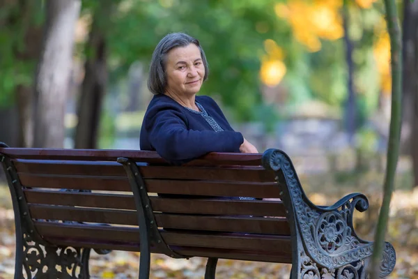 Mujer Anciana Sentada Banco Parque Otoño Mirando Sonriendo Cámara —  Fotos de Stock
