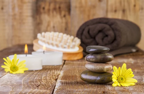 Pedras de basalto zen e óleo de spa com velas na madeira — Fotografia de Stock