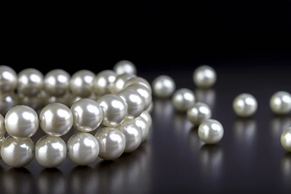 White pearls necklace on black — Stock Photo, Image