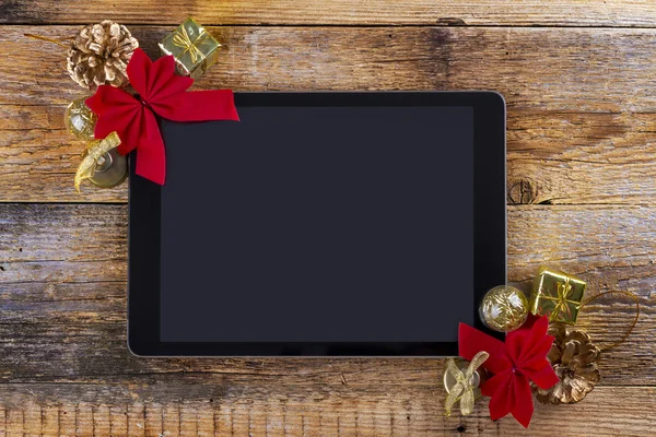 Tablet pc with  christmas decorations on wooden background — Stock Photo, Image