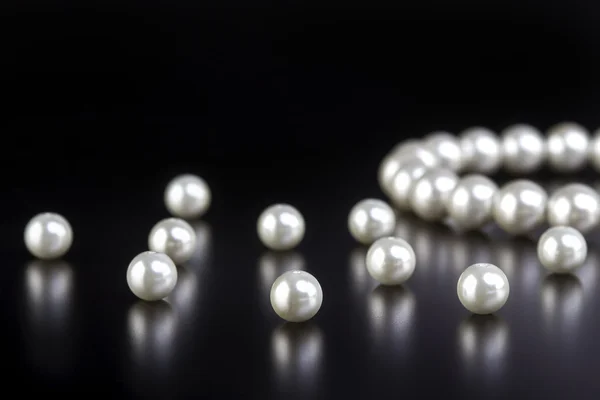 White pearls necklace on black — Stock Photo, Image