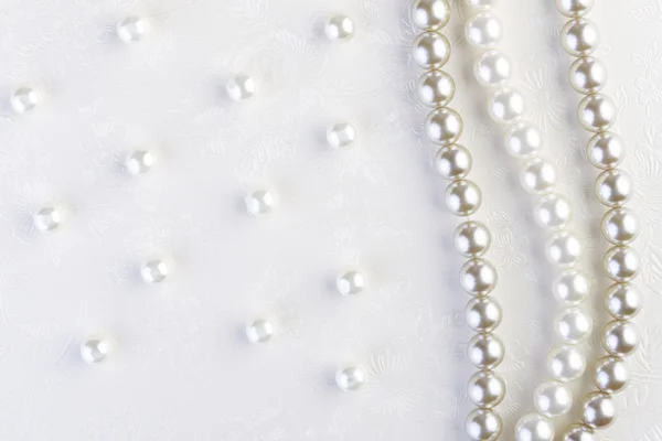 Кольє з білих перлів на білому папері — стокове фото