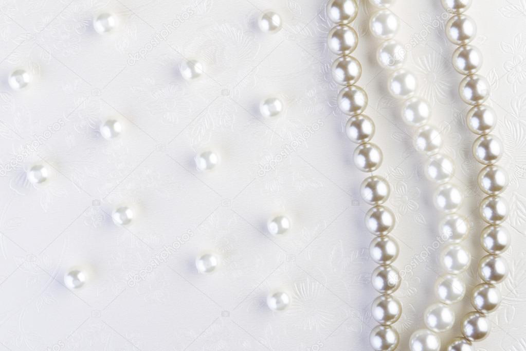 White pearls necklace on white paper  